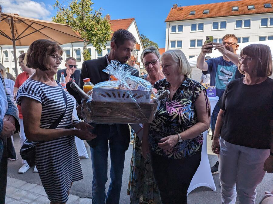 Zwei Frauen nehmen einen Geschenkkorb entgegen.