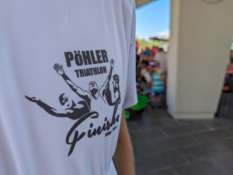 Das Shirt eines Triathleten in der Nahaufnahme. Das Logo des Triathlons ist darauf zu sehen.
