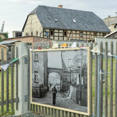 Bild vergr&ouml;&szlig;ern: Schwarz-Wei&szlig;-Fotos an den H&auml;usern lassen die in die Geschichte des Ortes eintauchen.
