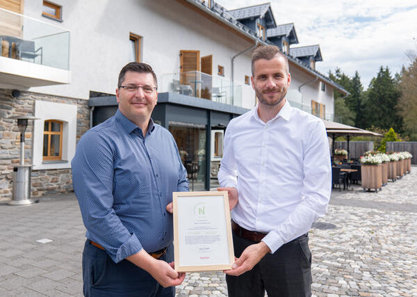 Bild vergr&ouml;&szlig;ern: Tannenhausgesch&auml;ftsf&uuml;hrer Tobias Werner und Landrat Thomas Hennig halten gemeinsam das NAchhaltigkeitszertifikat hoch