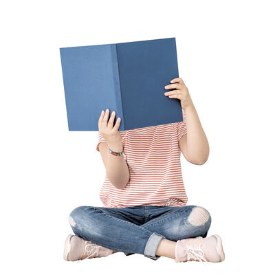 Bild vergr&ouml;&szlig;ern: M&auml;dchen sitzt im Schneidersitz und liest in einem gro&szlig;en blauen Buch