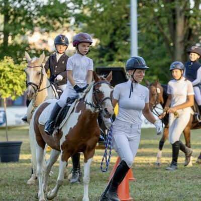 Bild vergr&ouml;&szlig;ern: Kinder und Jugendliche reiten mit ihren Pferden im Galopp.