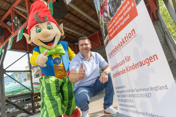 Bild vergr&ouml;&szlig;ern: Landrat Thomas Hennig und das Maskottchen "Plohni" zeigen den Daumen nach oben.
