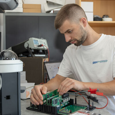 Bild vergr&ouml;&szlig;ern: Ein Techniker beim Zusammenbau einer Steuereinheit.