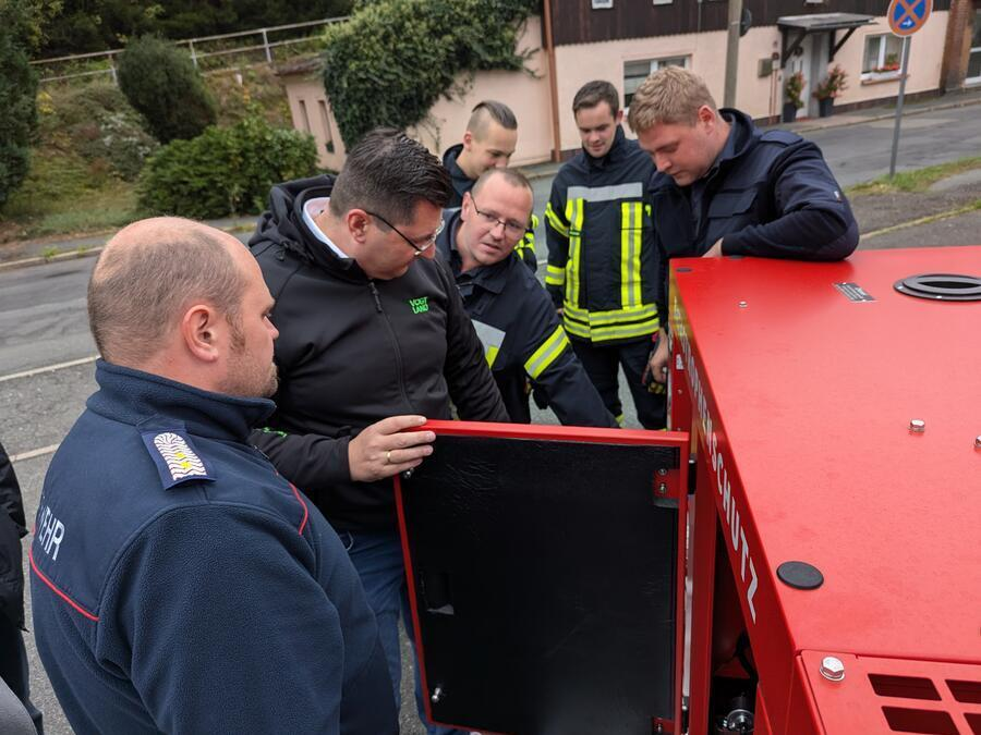 Landrat Thomas Hennig schaut in einen ge&ouml;ffneten Abschnitt des Ger&auml;tes.
