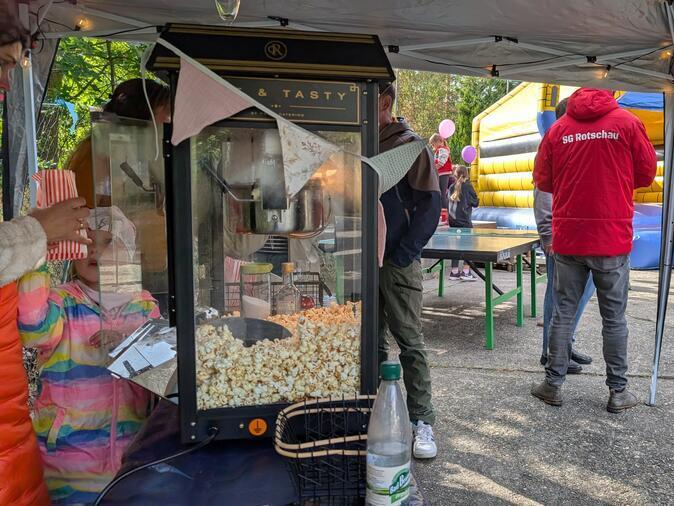 Im Vordergrund steht eine Popcornmaschine.