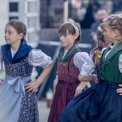 Bild vergr&ouml;&szlig;ern: Kinder in traditioneller Kleidung tanzen vor der B&uuml;hne.
