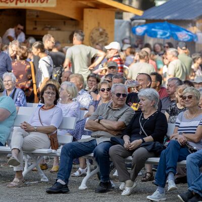 Bild vergr&ouml;&szlig;ern: Viele Besucher sitzen auf den St&uuml;hlen und schauen dem Programm auf der B&uuml;hne zu.