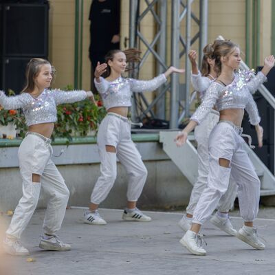 Bild vergr&ouml;&szlig;ern: Junge Frauen tanzen vor der B&uuml;hne in stylischer Kleidung.