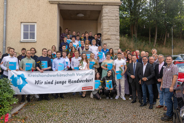 Bild vergr&ouml;&szlig;ern: Die Absolventen halten das Banner der Handwerkskammer hoch.