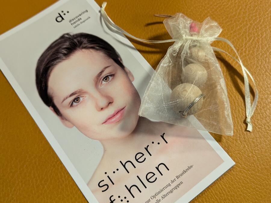 Ein Flyer und ein kleiner Beutel mit Holzkugeln.
