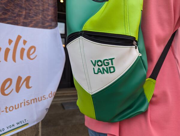 Bild vergr&ouml;&szlig;ern: Ein Rucksack, auf dem Vogtland geschrieben steht. Er ist in verschiedenen Gr�nt�nen gef�rbt.