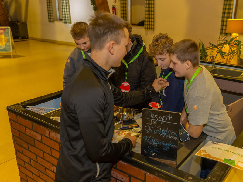 Jungen stehen in einer fingierten K&uuml;che.