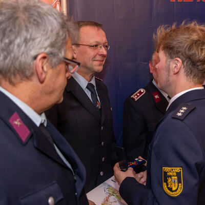 Bild vergr&ouml;&szlig;ern: Hauptamtlicher Kreisbrandmeister Gerd P&uuml;rzel bedankt sich bei Jens Zeidler von der Feuerwehr Limbach/ Ortsfeuerwehr Reimersgr&uuml;n