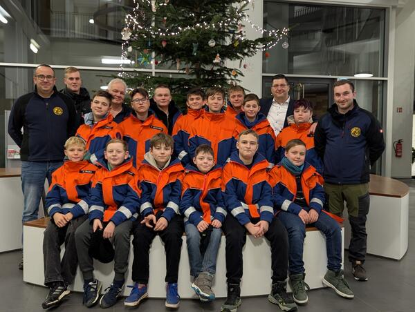 Bild vergr&ouml;&szlig;ern: Die Feuerwehr steht vor dem Weihnachtsbaum im Foyer.