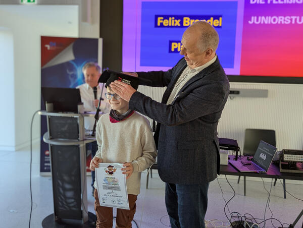Bild vergr&ouml;&szlig;ern: Professor Doktor Lutz Neumann, Rektor der Dualen Hochschule Plauen, zeichnet einen Juniordoktoranden aus.