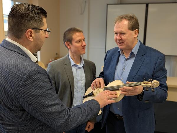Bild vergr&ouml;&szlig;ern: Landrat Thomas Hennig betrachtet eine unlackierte Geige.