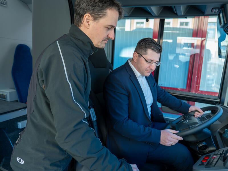 Landrat Thomas Hennig sitzt am Steuer eines Busses.