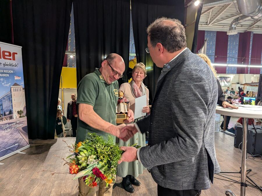 Ein Tischlermeister nimmt einen Preis entgegen.