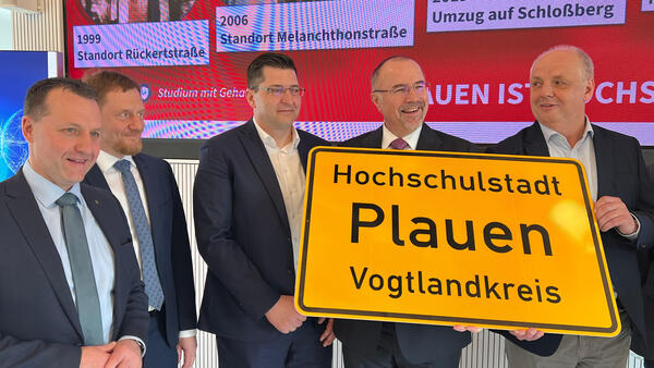 Bild vergr&ouml;&szlig;ern: Ministerpr�sident Michael Kretschmer, Landrat Thomas Hennig, Rektor Prof. Dr. Lutz Neumann und Oberb�rgermeister Steffen Zenner halten eines der neuen Ortsschilder.