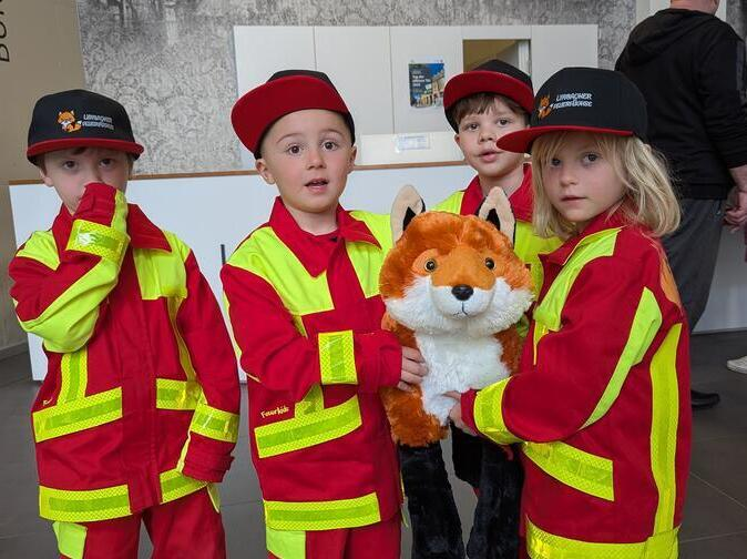 Vier Kinder halten einen Stofffuchs in der Hand