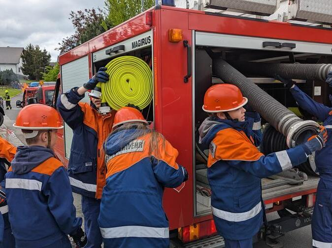Die Jugendfeuerwehr holt Schl&auml;uche aus dem Schlauchwagen.