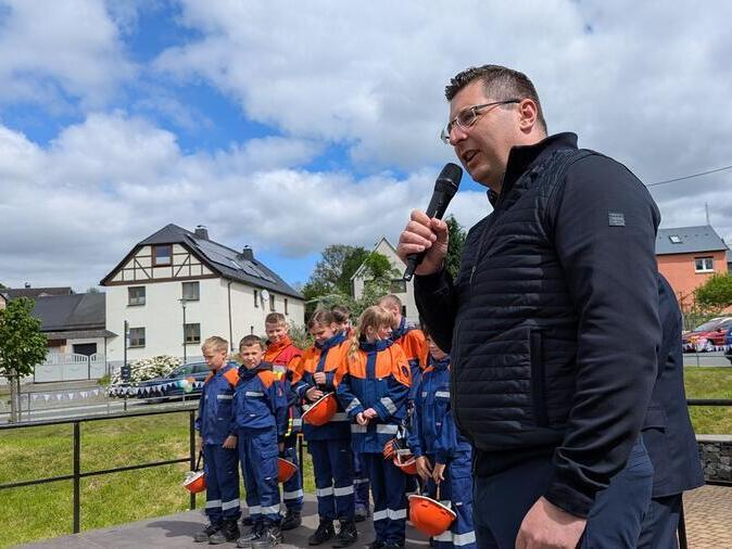 Landrat Thomas Hennig h&auml;lt eine Rede auf einer B&uuml;hne.