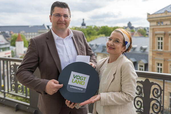 Bild vergr&ouml;&szlig;ern: Archivbild: Das Foto zeigt Landrat Thomas Hennig und Therese Langhof-Thomas mit einer Box auf dem Balkon des Hortenkaufhauses.