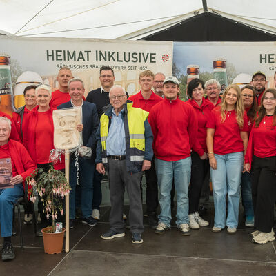 Bild vergr&ouml;&szlig;ern: Landrat Thomas Hennig steht zusammen mit dem Organisationsteam des IFA-Festivals zum Gruppenfoto in einer Reihe, alle l&auml;cheln in die Kamera.