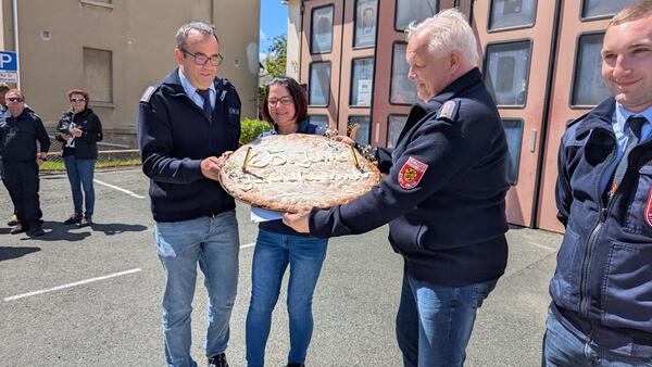 Bild vergr&ouml;&szlig;ern: Wehrleiter und Jugendwart nehmen einen Kuchen an.