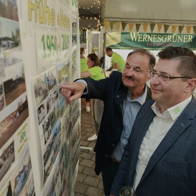 Bild vergr&ouml;&szlig;ern: Bert Blechschmidt zeigte dem Landrat Thomas Hennig die Entwicklung der Gemeinde an der Fotoausstellung.