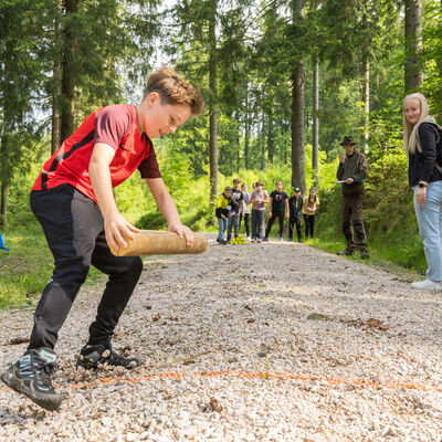 Bild vergr&ouml;&szlig;ern: Ein Junge rennt mit einem Holzst&uuml;ck vom Start zum Ziel. Die schnellste Gruppe gewinnt.