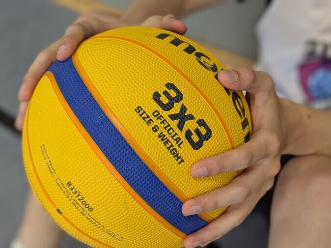 Ein gelber Basketball mit dem 3x3-Logo.