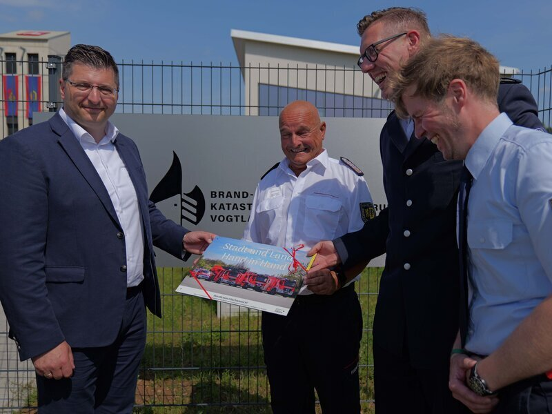 Vertreter der Stadt Plauen &uuml;bergeben ein Geschenk an Landrat Thomas Hennig, Kreisbrandmeister Gerd P&uuml;rzel und Andreas Schubert vom Kreisfeuerwehrverand.