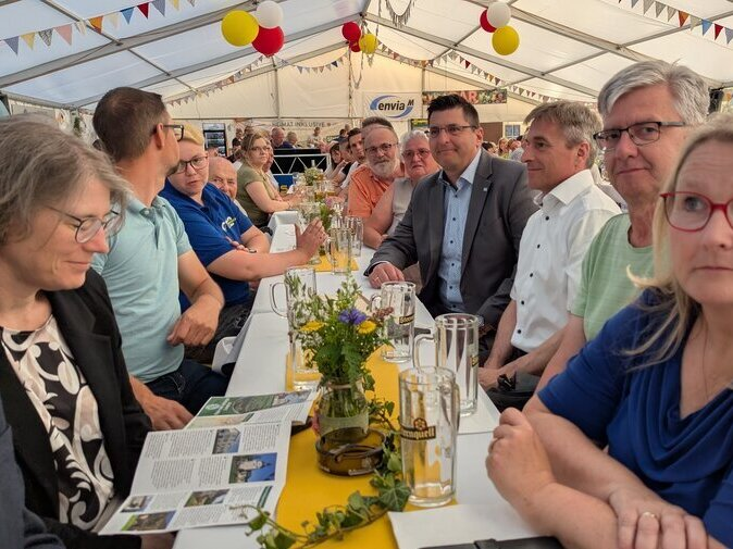 Leute sitzen an einem Biertisch.