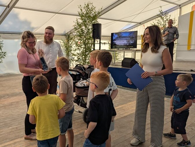 Kinder beschenken ein frisches Elternpaar.