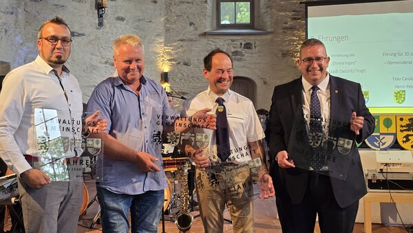 Bild vergr&ouml;&szlig;ern: Vier B&uuml;rgermeister halten Plaketten hoch.