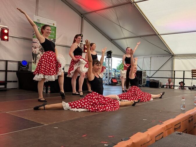 Frauen in Rockabilly-Kleidern nehmen eine Abschlusspose ein.