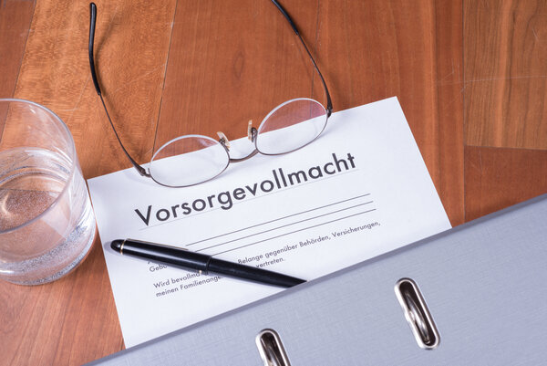 Bild vergr&ouml;&szlig;ern: Das Bild zeigt eine Brille, ein Glas Wasser und einen Ordner. Darunter liegt ein Zettel mit der �berschrift "Vorsorgevollmacht"