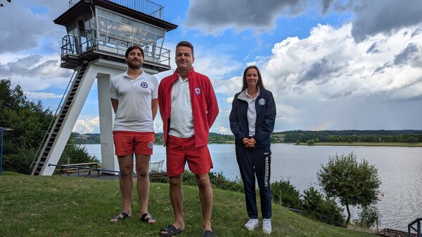 Bild vergr&ouml;&szlig;ern: Drei Mitglieder der Wasserwacht Reichenbach stehen vor einem Wachtturm.