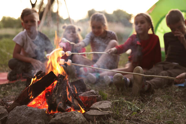Bild vergr&ouml;&szlig;ern: Auf dem Bild sieht man Kinder, welche an einem Lagerfeuer sitzen.