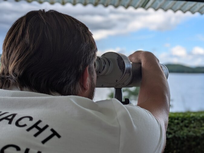 Ein Mann blickt durch ein Fernglas.