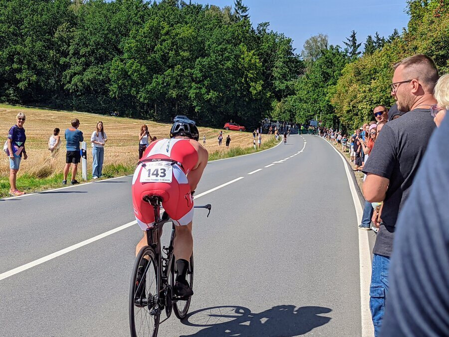 Ein Radfahrer f&auml;hrt an einer Besuchermenge vorbei.