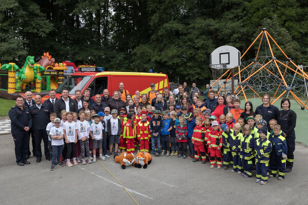 Bild vergr&ouml;&szlig;ern: Gruppenfoto von den Kindern, Ausbildern, Feuerwehrleuten und Helfern.