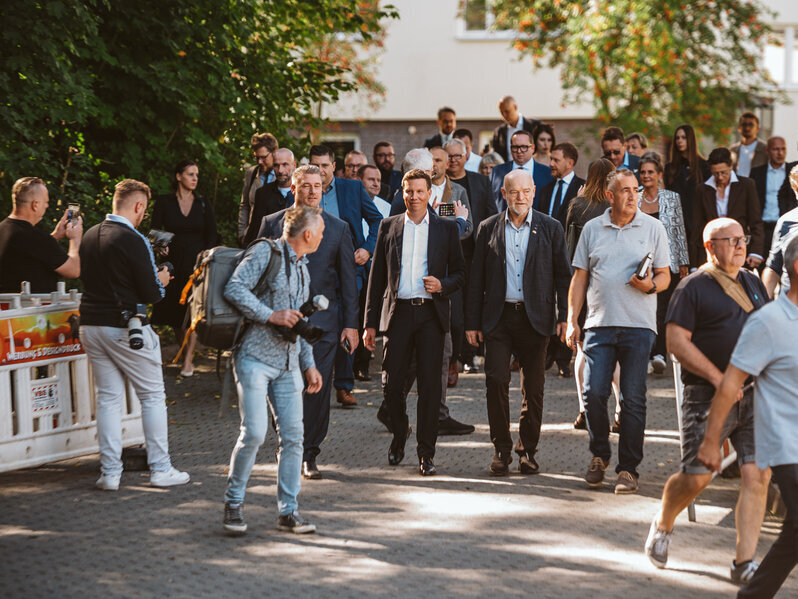 Die Delegation geht &uuml;ber das Gel&auml;nde.