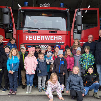 Das Bild zeigt die Kinder des Schulhortes aus Muldenhammer vor einem gro&szlig;en roten Feuerwehrauto.