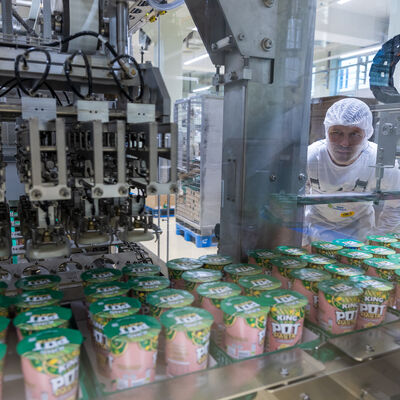 Bild vergr&ouml;&szlig;ern: Ein Mitarbeiter &uuml;berwacht die Arbeit der Fertigungslinie f&uuml;r Snack-Pots.