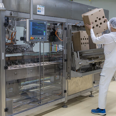 Bild vergr&ouml;&szlig;ern: Ein Mitarbeiter best&uuml;ckt die Anlage mit Verpackungsmaterial.