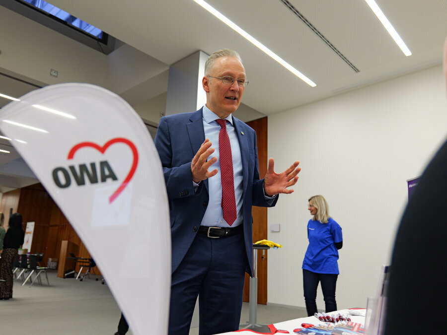 Dr. Axel Steinbach unterh&auml;lt sich mit jemandem am Stand der AWO.