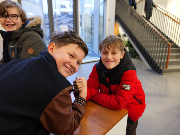 Bild vergr&ouml;&szlig;ern: Zwei Jungen machen Armdr�cken. Sie lachen dabei in die Kamera.